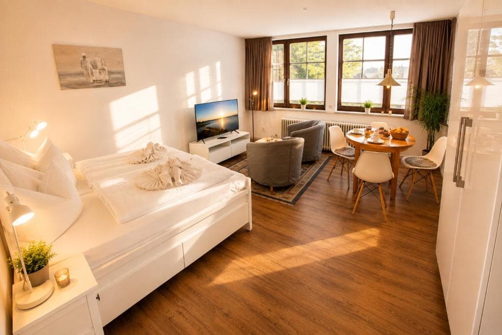 Wohn- und Schlafraum mit Doppelbett, Sitzecke und Essplatz am Fenster
